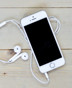 White-iPhone-On-Wooden-Desk-With-Headphones